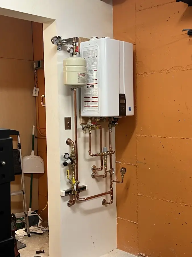 Plumbing technician inspecting water heater connections in Ajo